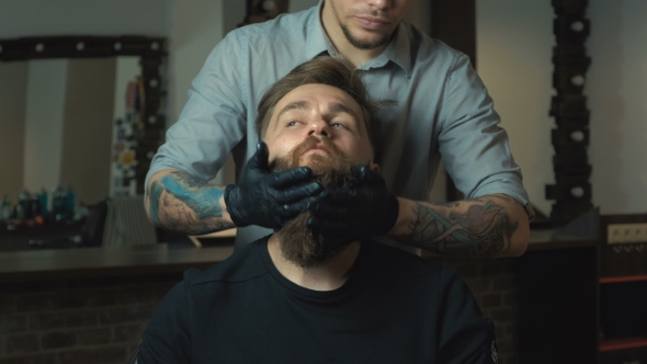 Handsome Man with a Long Beard and Undercut in Barbershop