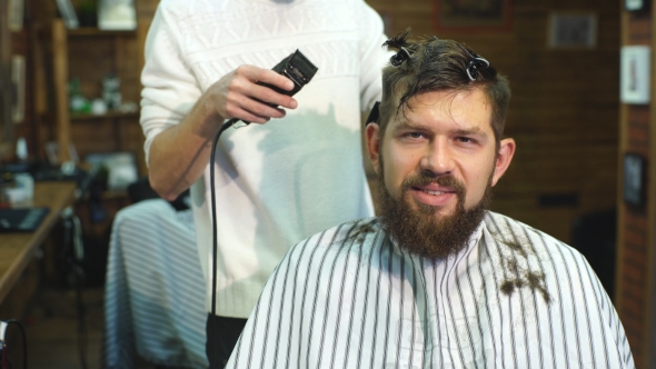 Hairdresser Makes Hairstyle a Man with a Beard
