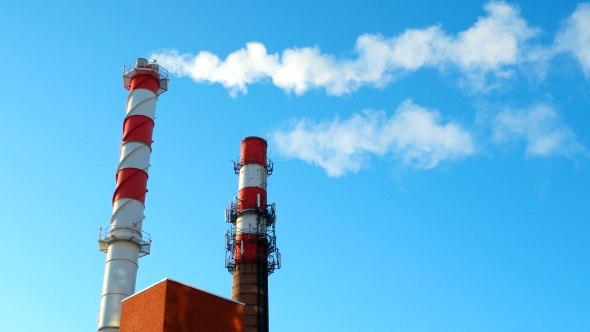 Boiler House Chimney. Steam Against the Clear Blue Sky. Industrial Zone of the City.