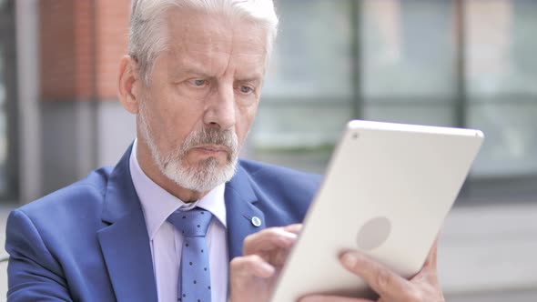 Old Businessman Using Tablet Outdoor