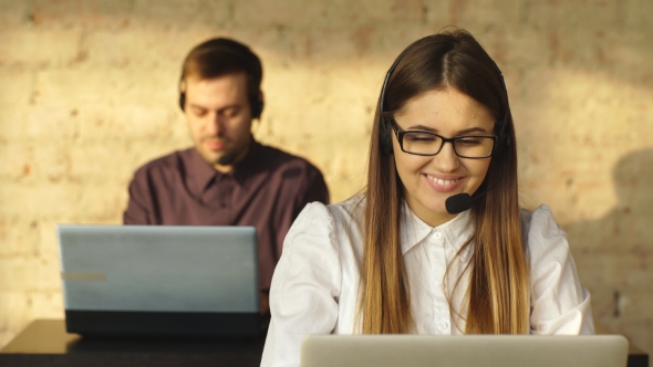 Man and Woman in Headphones Working in Call Center