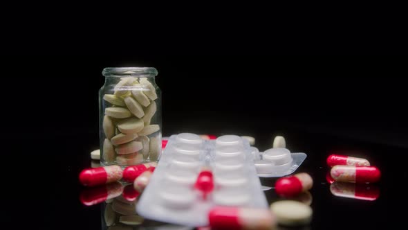 Closeup of Medicine Tablets on Black Background Shooting of Red and White Drugs on the Table