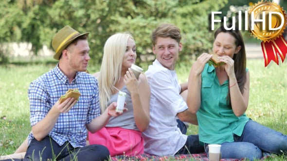 Young People Eating and Drinking on a Lawn