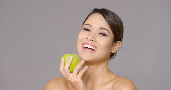 Laughing Healthy Young Woman with a Green Apple