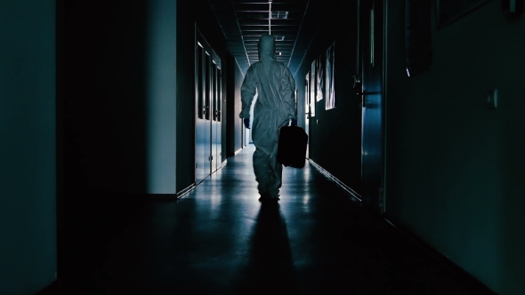 The Scientist in Protective Suit and with Bag Going Through the Corridor alt