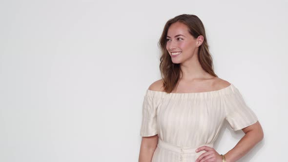 Woman Wearing an Off-shoulder Dress Standing at a Studio with White Backdrop