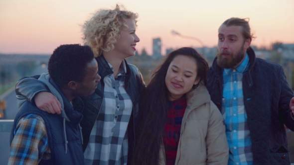 Diverse Family of Four Stand at Railing and Laugh