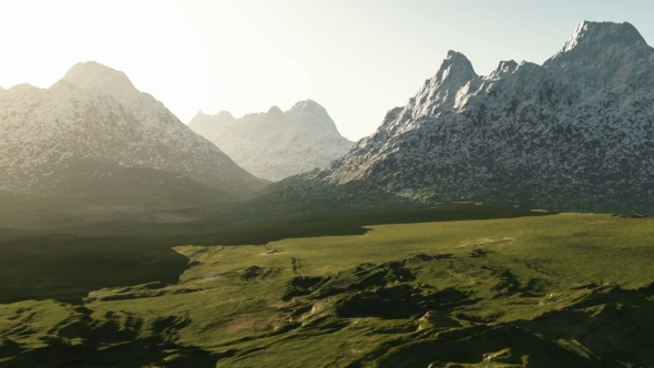 Green Valley and Mountains in Snow at Sunset alt
