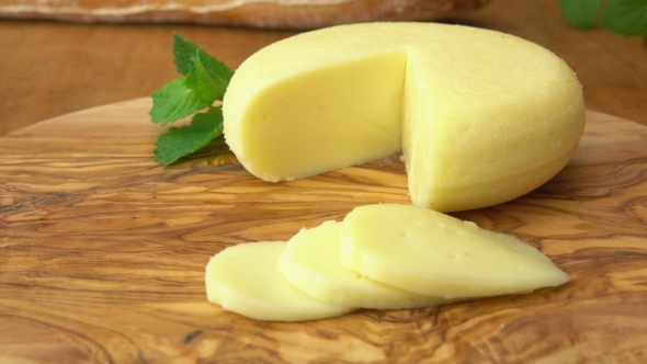 Babybel Cheese Head on the Rustic Table with Sliced Pieces