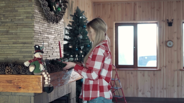 Woman Decorating Fireplace for Christmas