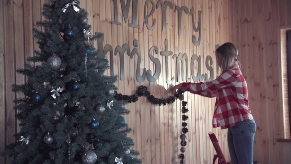 Woman Putting Up Christmas Decorations