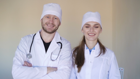 Young Female Doctor and a Male Doctor Looking at the Camera and Smiling