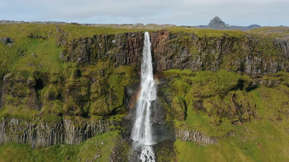 Aerial Drone Footage of Bjarnarfoss Waterfall with Its Green Cliffs in Western Iceland