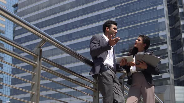 Young Indian businessman talking with businesswoman partner