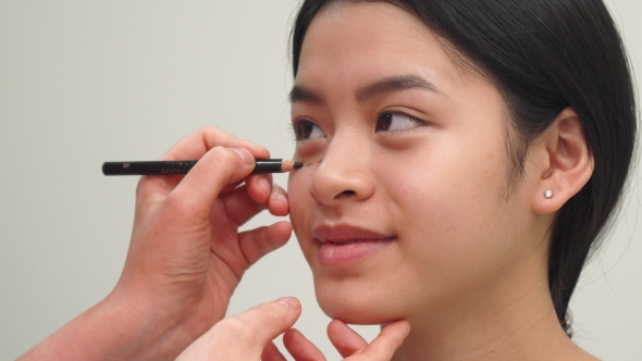 Cosmetologist Draws Lines Under Girl's Eye