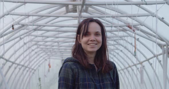 Woman Walking Through a Greenhouse