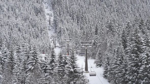 Chairlift Lifts Skiers on Slope