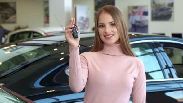 Woman Shows the Car Key at the Dealership