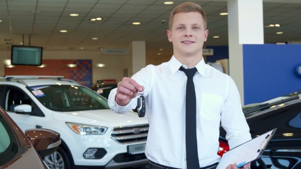 Sales Manager Shows Car Key at the Dealership