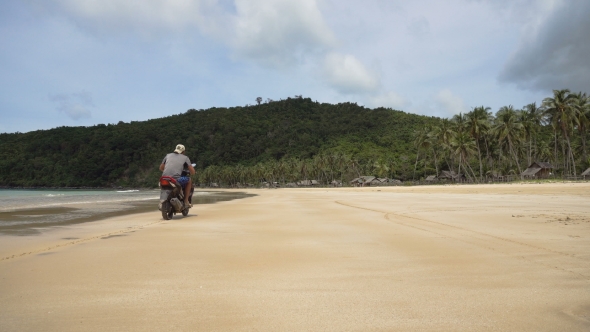 Man Driving a Motorcycle on Beach