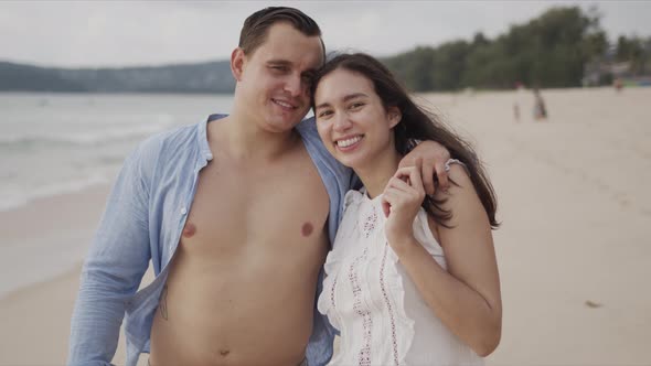 Happy Lovers Travelers Embracing and Smiling at Exotic Seaside