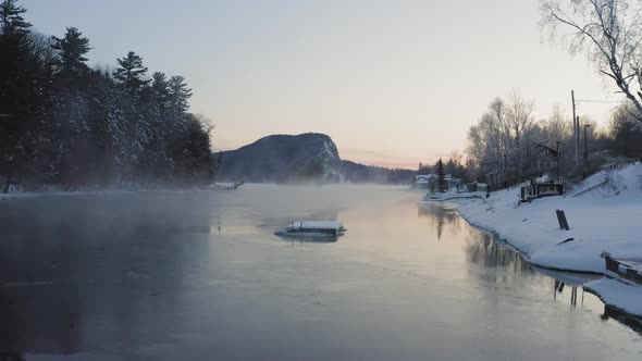 Breathtaking view of Mount Kineo flying low over Moosehead Lake frozen in Winter