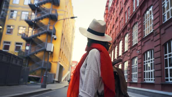 Beautiful young female tourist in a hat walking in the city