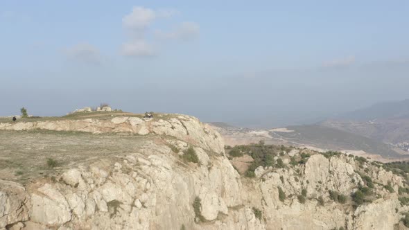 Tourists Eat Kebab Sitting on Stone Cliff Among Mountains