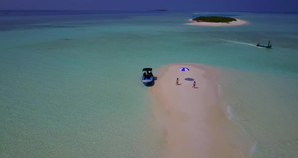 Daytime aerial tourism shot of a white paradise beach and aqua blue water background in colourful 4K