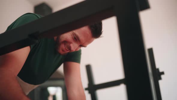 Man Smiling And Talking While Assembling A DIY Table At Home. low angle