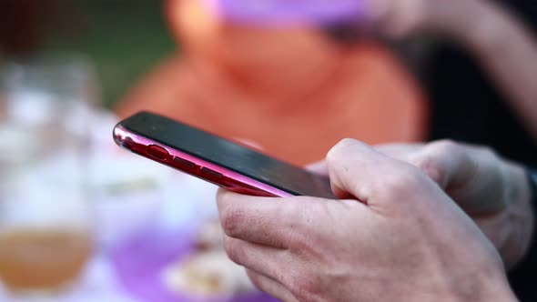 mans hands are using smartphone, writing message or downloading an app for his mobile phone at home 