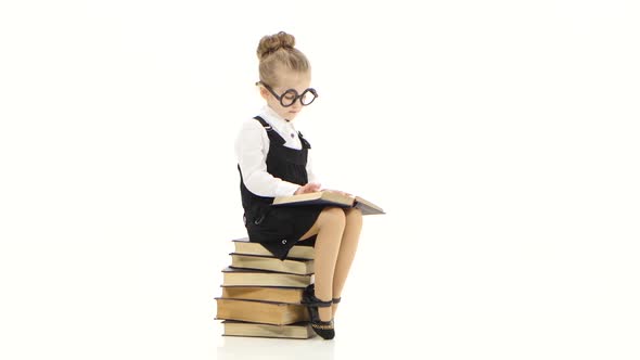 Little Girl in Glasses Reads Big Book on White Studio