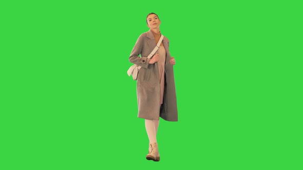 Young Woman In a Coat Dancing While Walking on a Green Screen Chroma Key