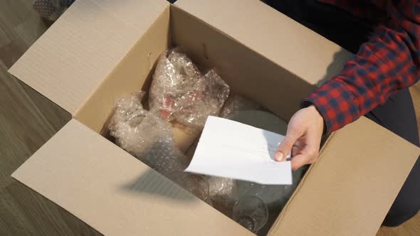 A Man Unpacks Boxes After Moving to a New Apartment