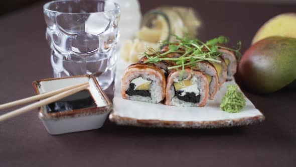 Set of sushi with herbs and eel on a white clay plate