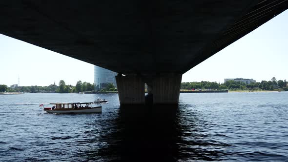 Small cruise ship sailing uner the Vanšu Bridge in Riga