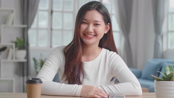 Asian Girl Waving Hand And Smiling To Camera