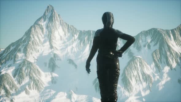 Woman Standing In Snow Wearing Warm Clothes In Mountains