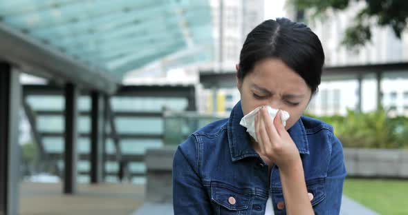 Woman sneeze at outdoor 