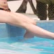 Close Up Of Legs Of A Woman Sitting By The Pool - VideoHive Item for Sale