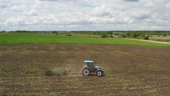 A Tractor with a Cultivator Working in the Field, Aerial View