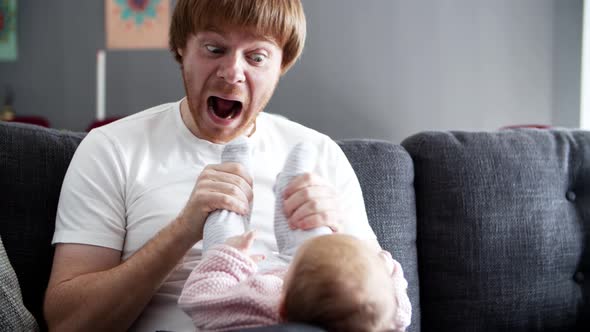 Funny Dad Grimacing and Playing with Baby Daughter