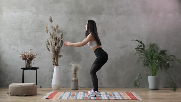 Young Woman Goes in for Sport on the Background of a Gray Concrete Wall