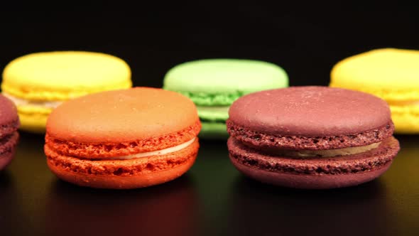 A rows of a colorful macaroons is on the black table