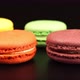 A rows of a colorful macaroons is on the black table - VideoHive Item for Sale
