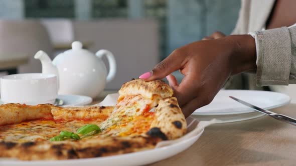 AfricanAmerican Lady Takes Slice of Pizza at Dinner in Cafe