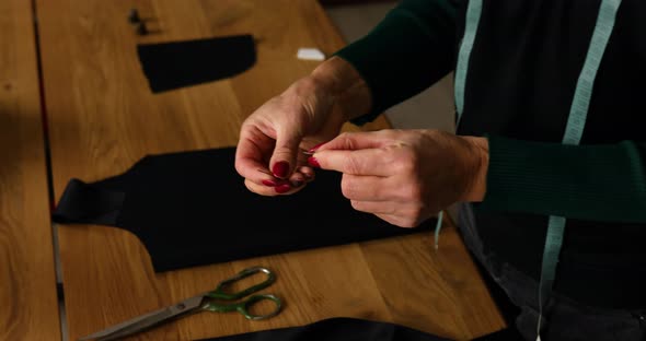 Step by step, woman dressmaker pulling thread into the needle