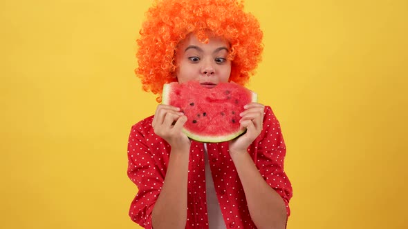 Cheerful Kid in Orange Hair Wig Eating Slice of Watermelon Fruit on Yellow Background Summer