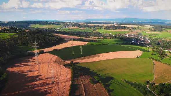 Wheat yellow and green agriculture fields with electricity power lines and transmission towers