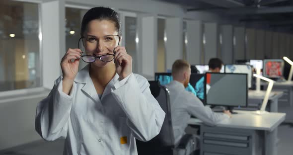 Female Cheerful Engineer in Lab Coat and Glasses in Office